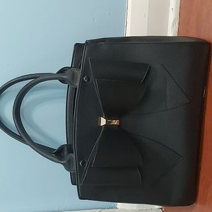 Black handbag with bow detail and gold hardware